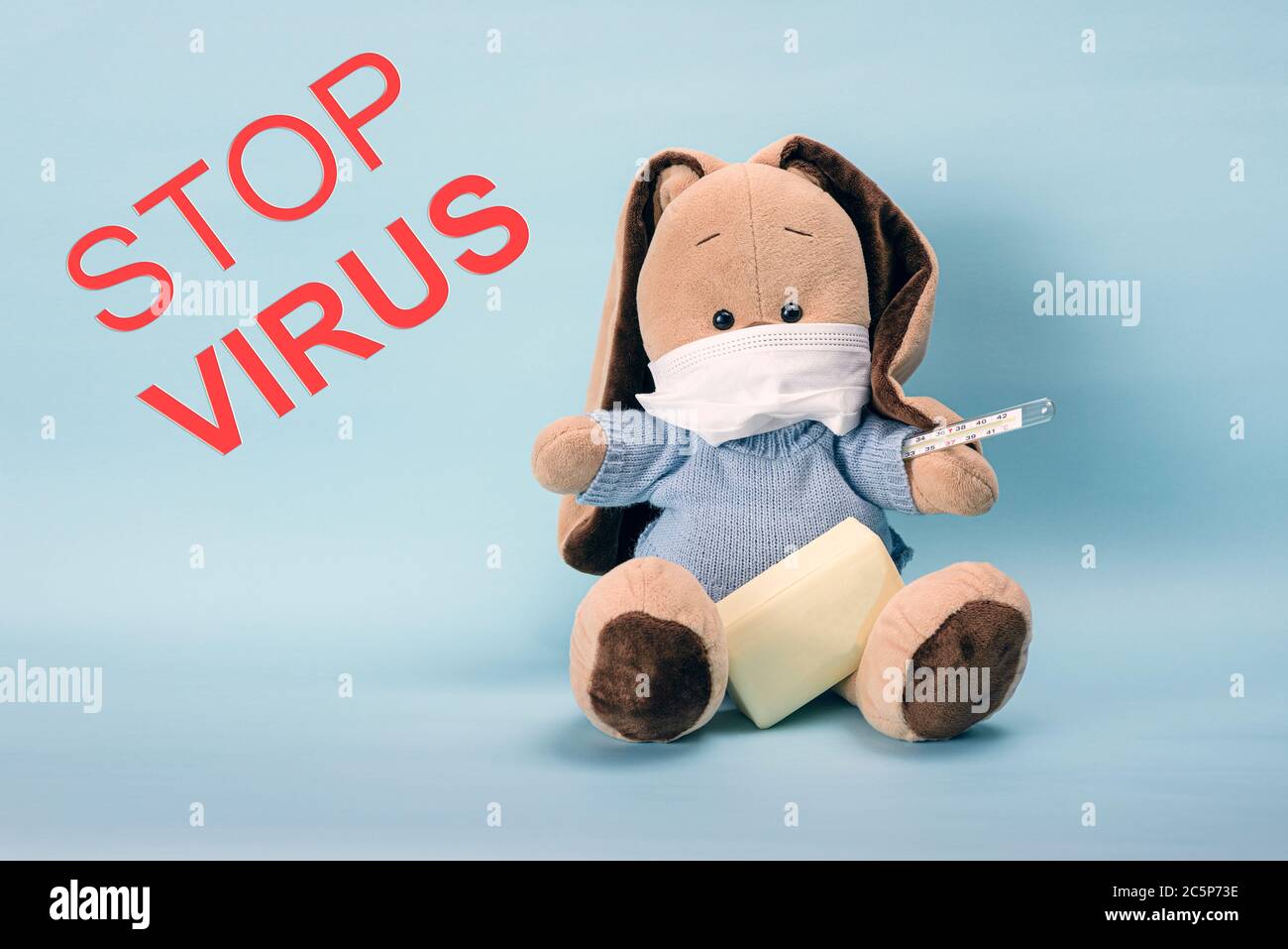 Stop Virus! Sitting bunny in a protective mask with soap in his paws, the concept of the fight against virus. Anti-virus protective mask prevent infec Stock Photo