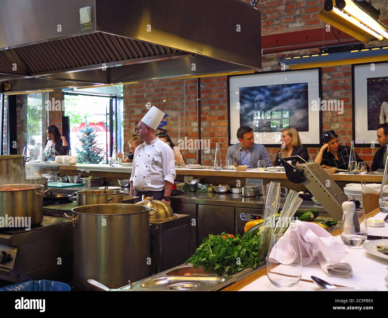 People eating in open kichen of Warszawa Wschodnia restaurant in the