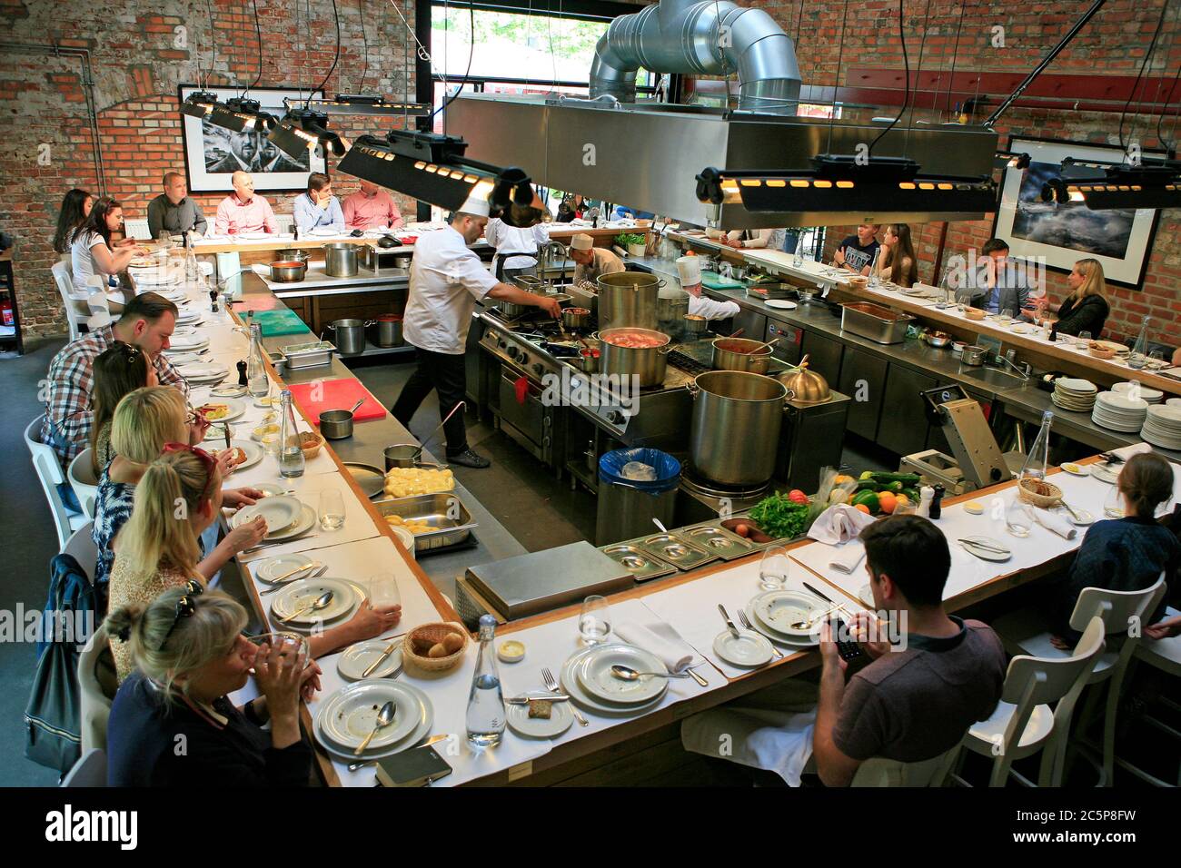 People eating in open kichen of Warszawa Wschodnia restaurant in the