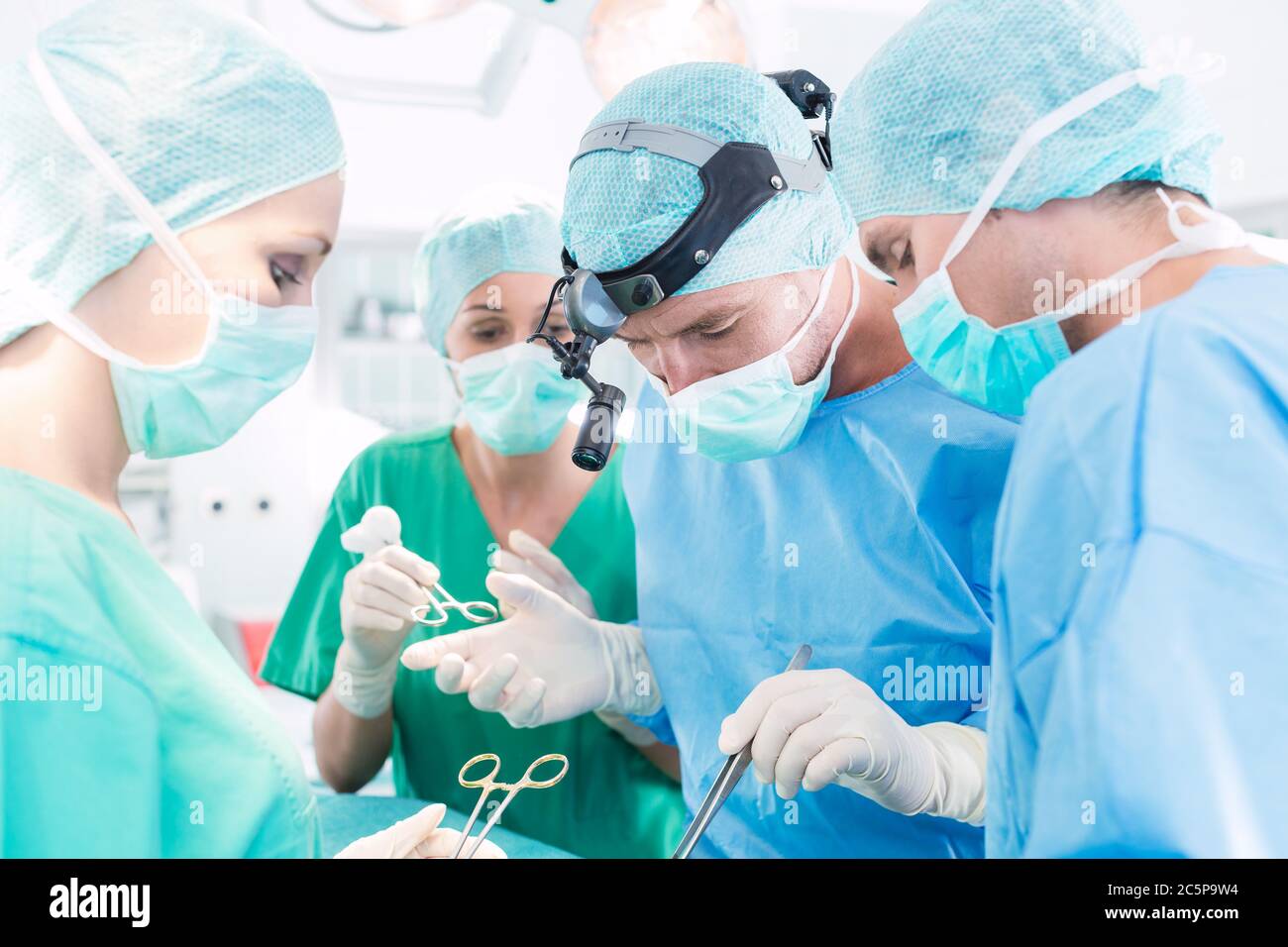 Surgeons operating patient in operation theater Stock Photo