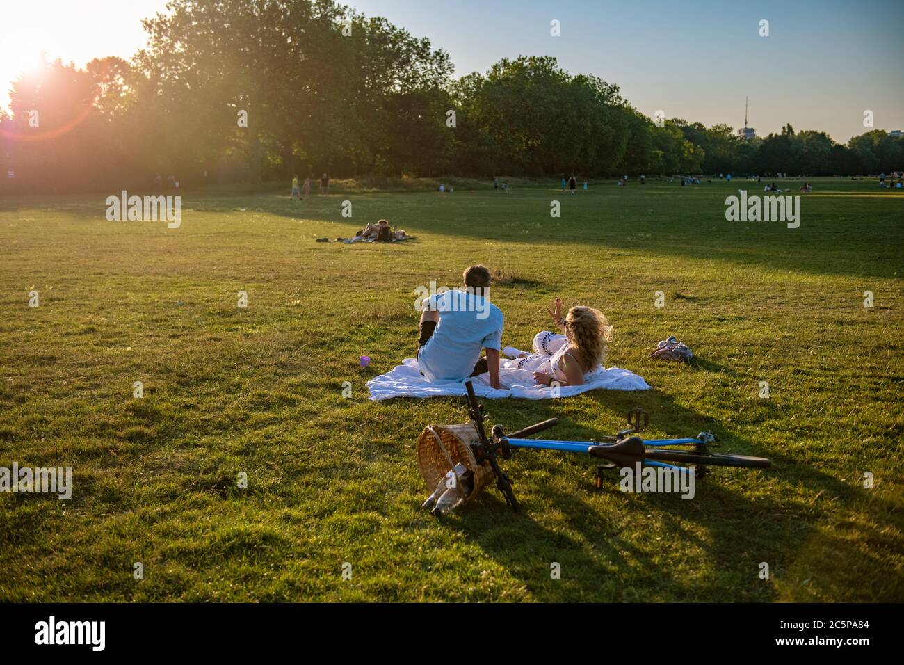 A couple enjoy the sun in coronavirus lockdown - summer in a London park Stock Photo