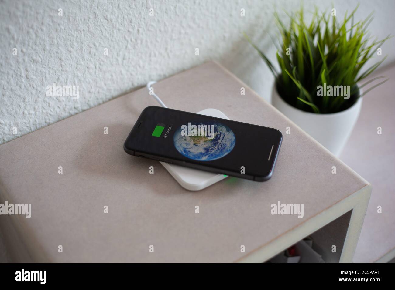 Smartphone on wireless charging pad to charge battery Stock Photo