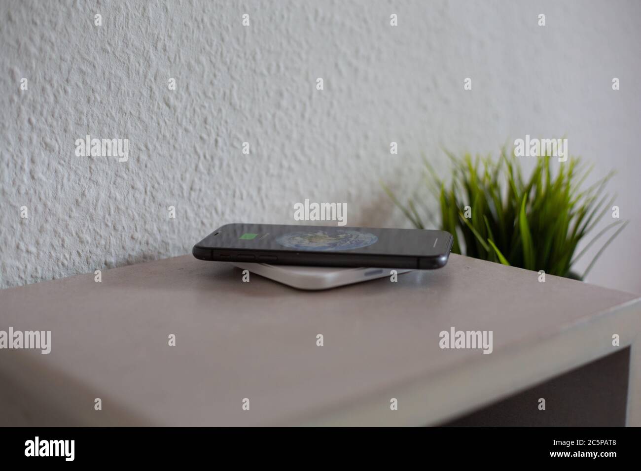Smartphone on wireless charging pad to charge battery Stock Photo