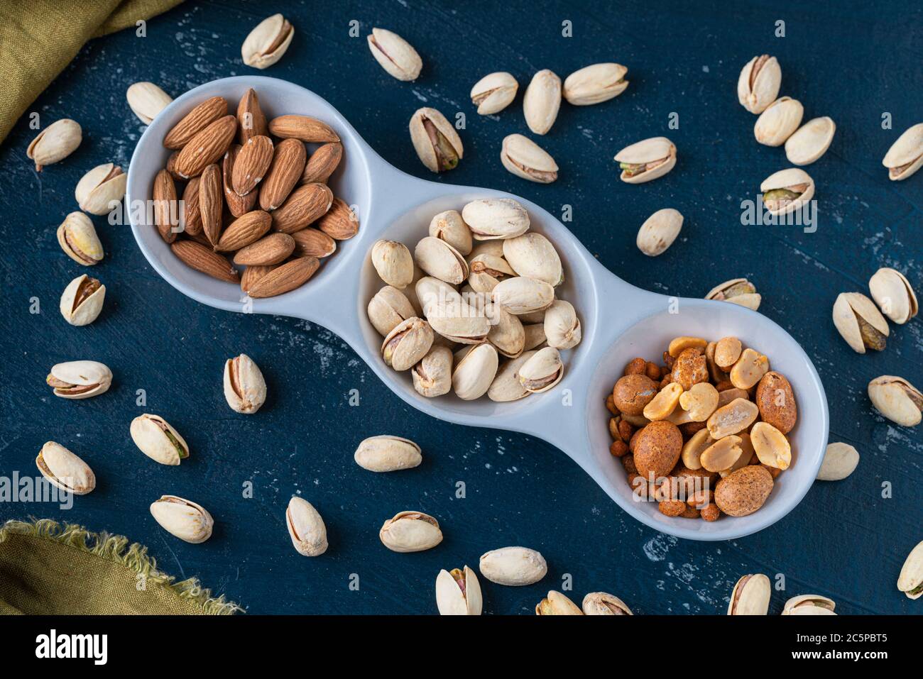 Roasted Nuts And Salted Pistachios In White Ceramic Bowl Stock Photo