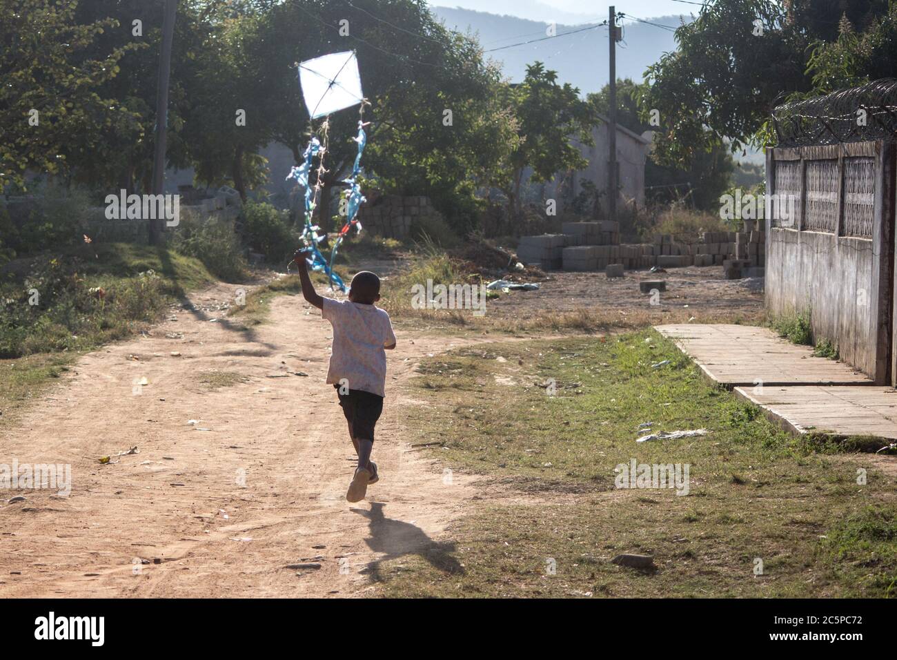 Boy flying kite toy made of recycled plastic bags and sticks in Africa Stock Photo Alamy
