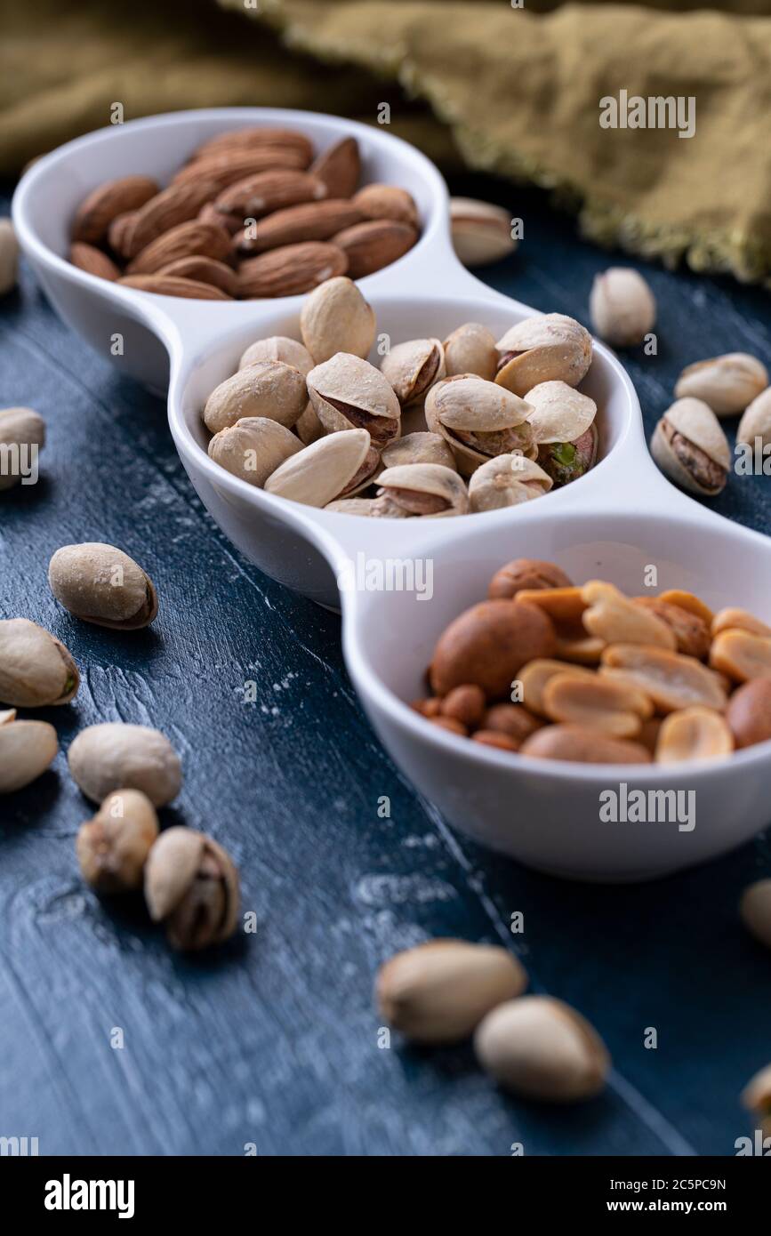 Roasted Nuts And Salted Pistachios In White Ceramic Bowl Stock Photo