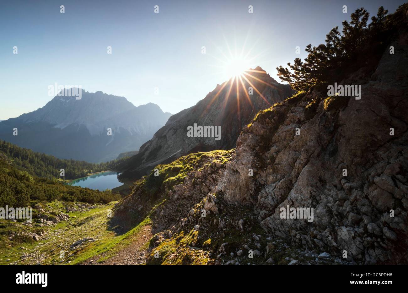 beautiful sunrise over mountain peaks and lake in summer Alps Stock Photo