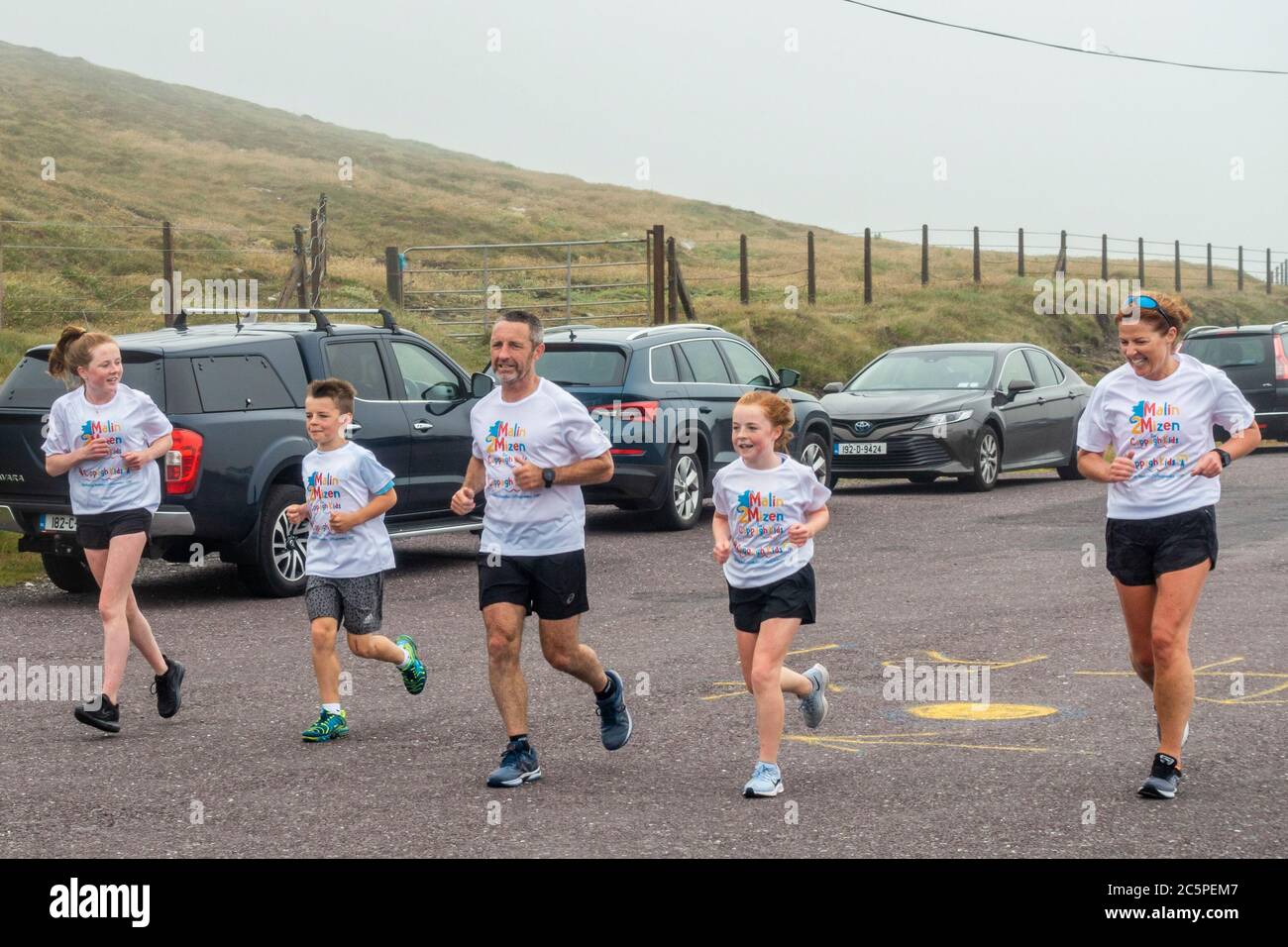 West Cork, Ireland. 4th July, 2020. Barry Sheehan, who lives in Cork, has ran 600 kms from Malin to Mizen Head in aid of the new children's unit 'Cappagh Kids' of National Orthopaedic Hospital, Cappagh, Dublin. Barry is pictured approaching the finish line with his wife, Jen and his children, Grace, Michael and Ciara. Credit: AG News/Alamy Live News Stock Photo