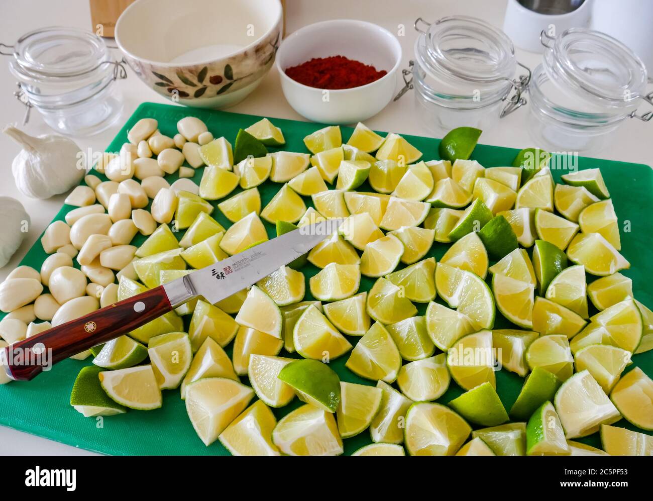 Preparation to make lime pickle on kitchen counter with garlic and