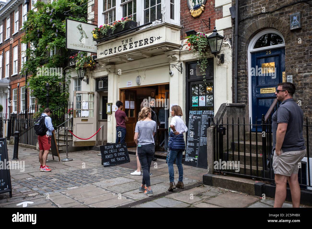 Queues outside 'The Cricketers' public house during the gradual reopening after coronavirus COVID-19 lockdown, The Green, Richmond, Southwest London Stock Photo