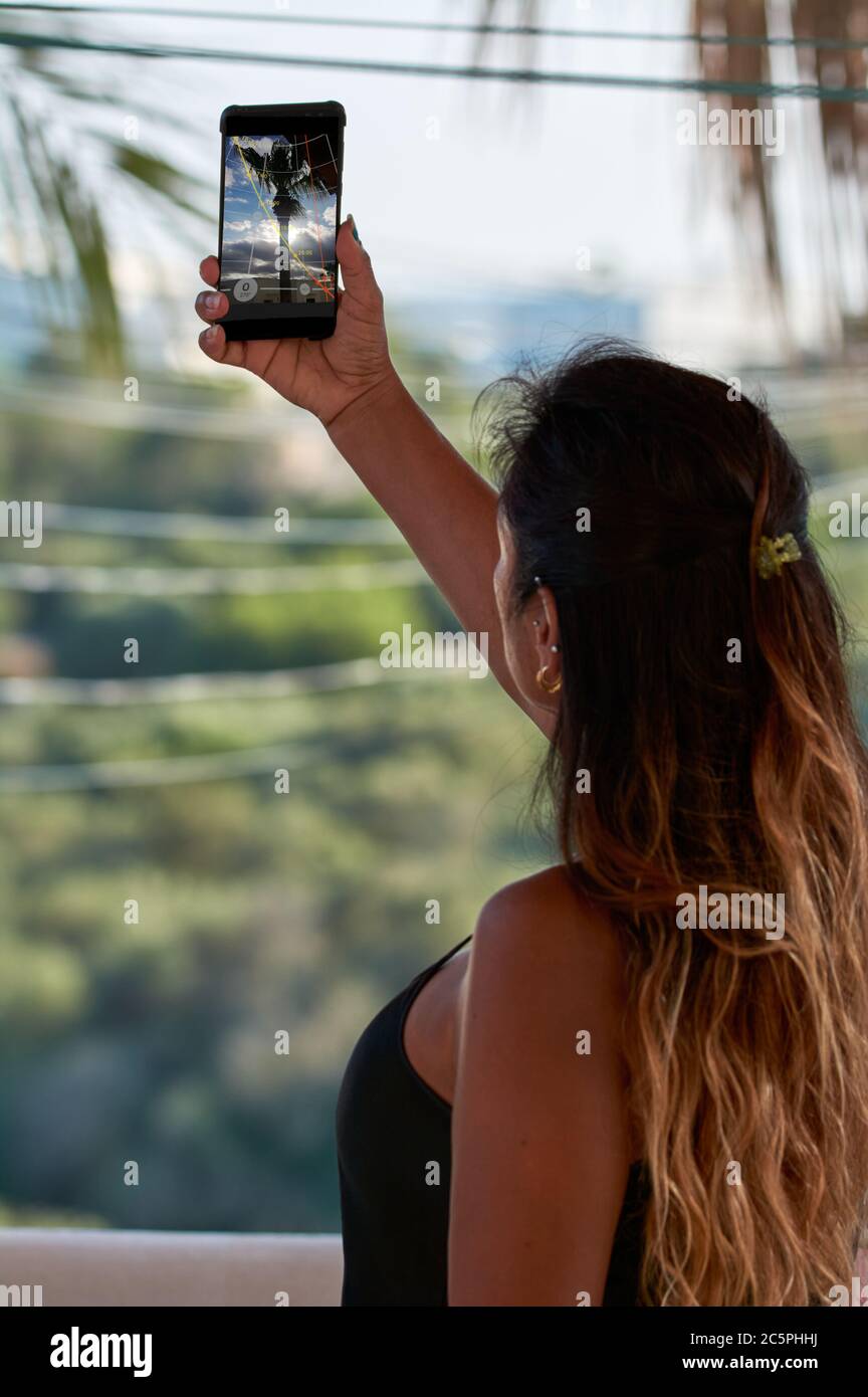 smartphone screen cutout, latin woman with using smartphone, augmented reality, taking selfi, Stock Photo