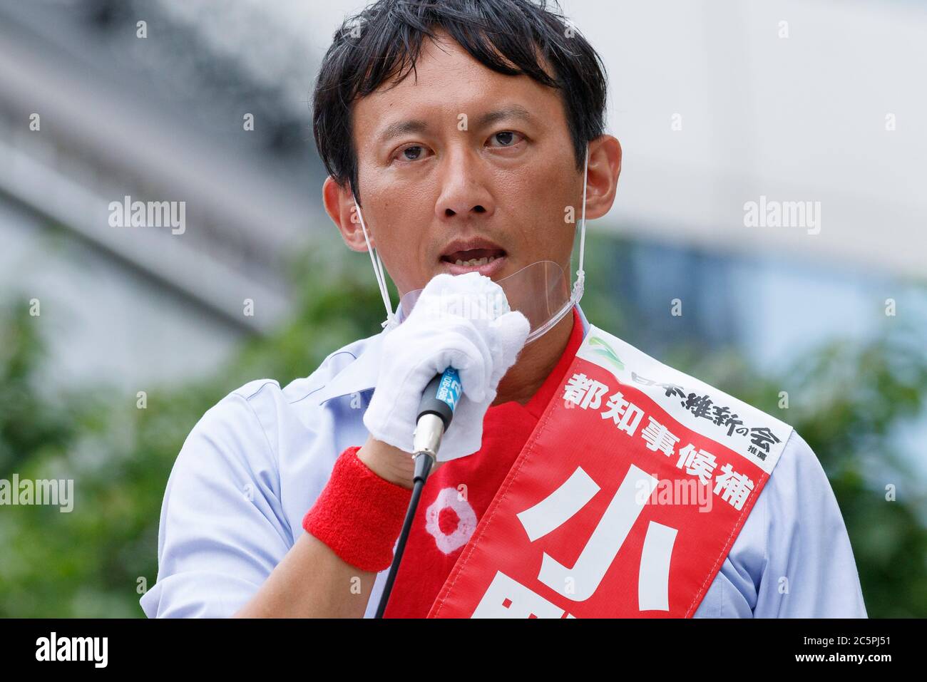 Tokyo, Japan. 4th July, 2020. Candidate Taisuke Ono wearing a mouth shield delivers a street speech while campaigning for tomorrow's gubernatorial election near to Ginza. Tokyo city will run its gubernatorial election on July 5. Tokyo reported 131 new coronavirus cases on Saturday. Credit: Rodrigo Reyes Marin/ZUMA Wire/Alamy Live News Stock Photo