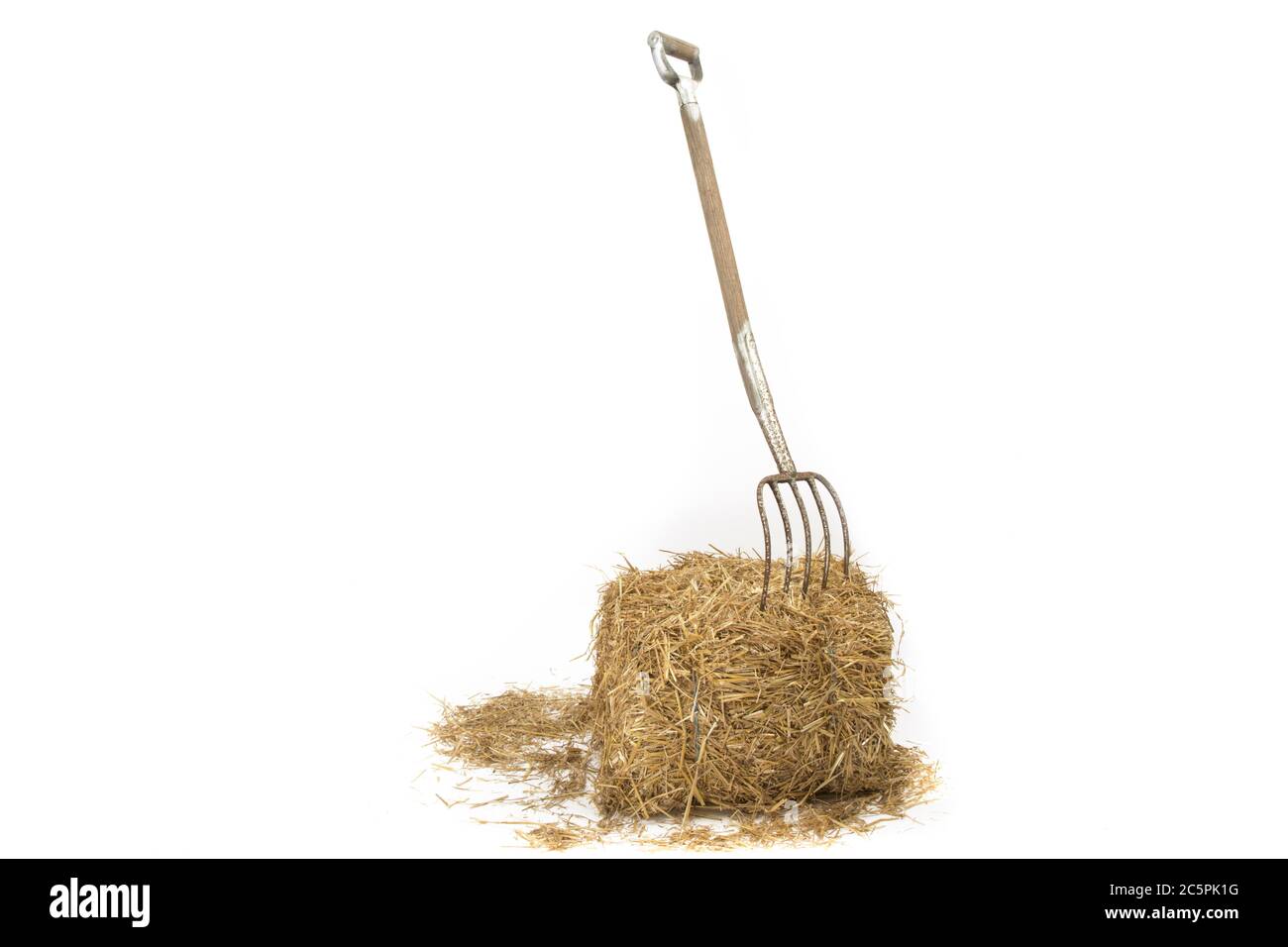 a pitch fork stuck into a bale of straw Stock Photo