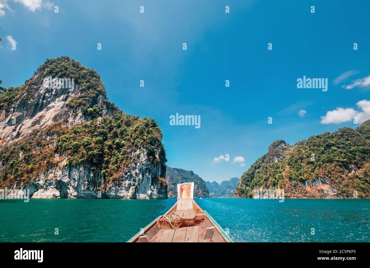 Nose of wooden motorboat view, vessel sailing on Thai Khao Sok Lake with foresty mountains around Stock Photo
