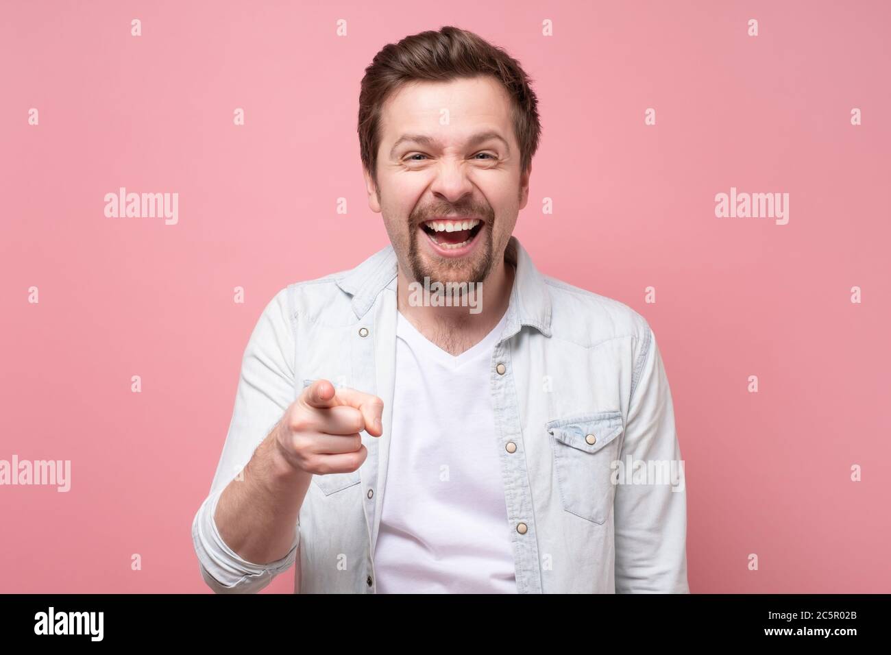 smiling man pointing fingers at camera, picking you Stock Photo