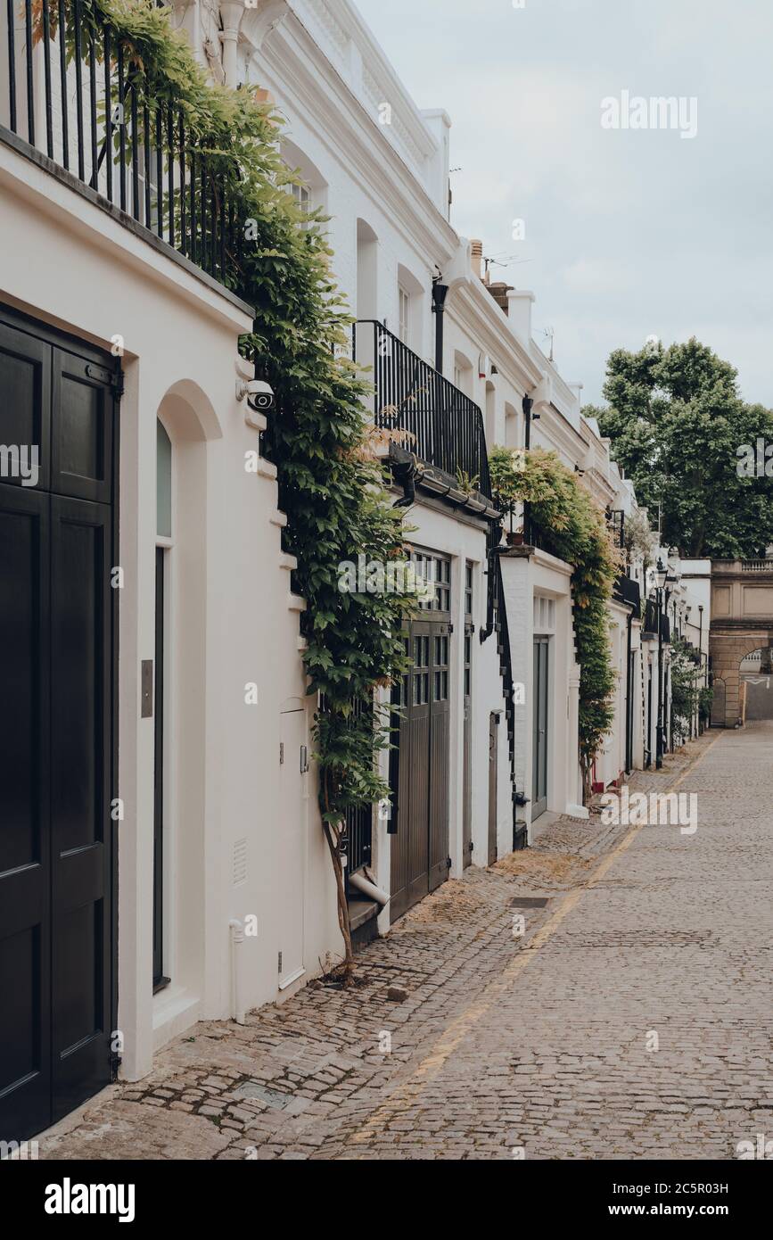 Facade of a typical row of mews houses with garages in London, UK. Real