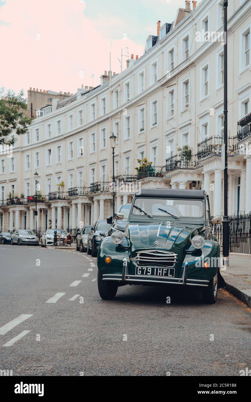 London, UK - June 20, 2020: Old Citroen 2CV parked on a street in Holland park, an affluent area of West London favoured by celebrities, white Victori Stock Photo