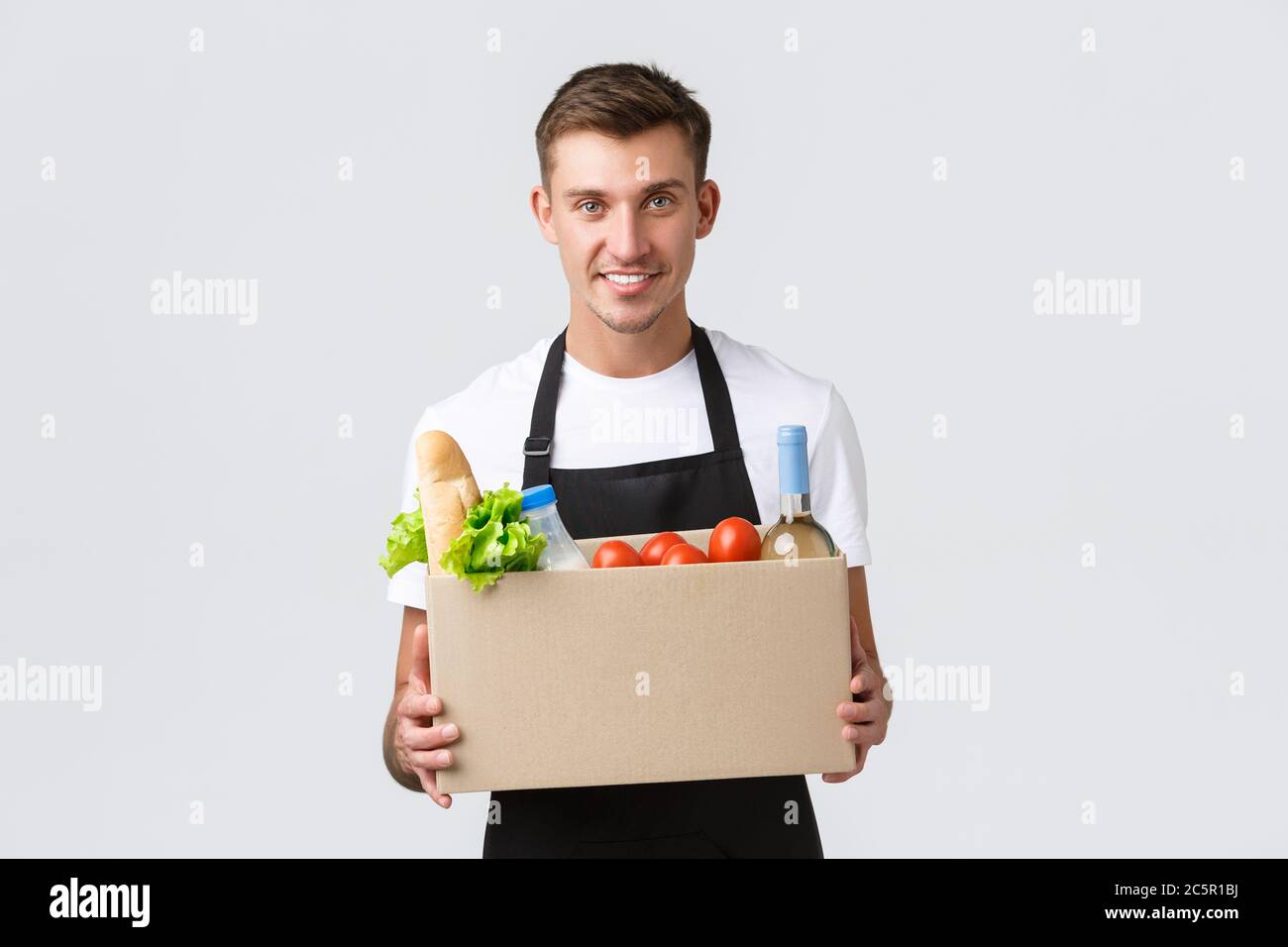 Retail, grocery shopping and delivery concept. Handsome courier in