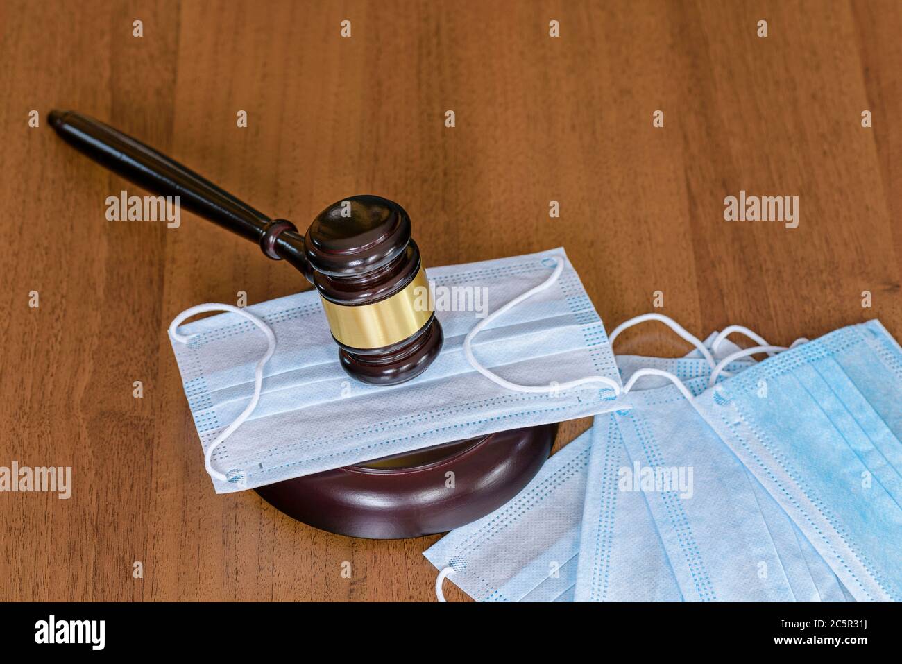 Trial of medical workers. Judicial hammer lies on medical masks. Concept of mandatory wearing of medical masks during the flu season. Coronvirus contr Stock Photo