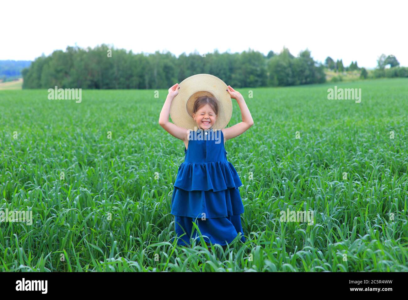 Beautiful little girl runs in the summer field Stock Photo