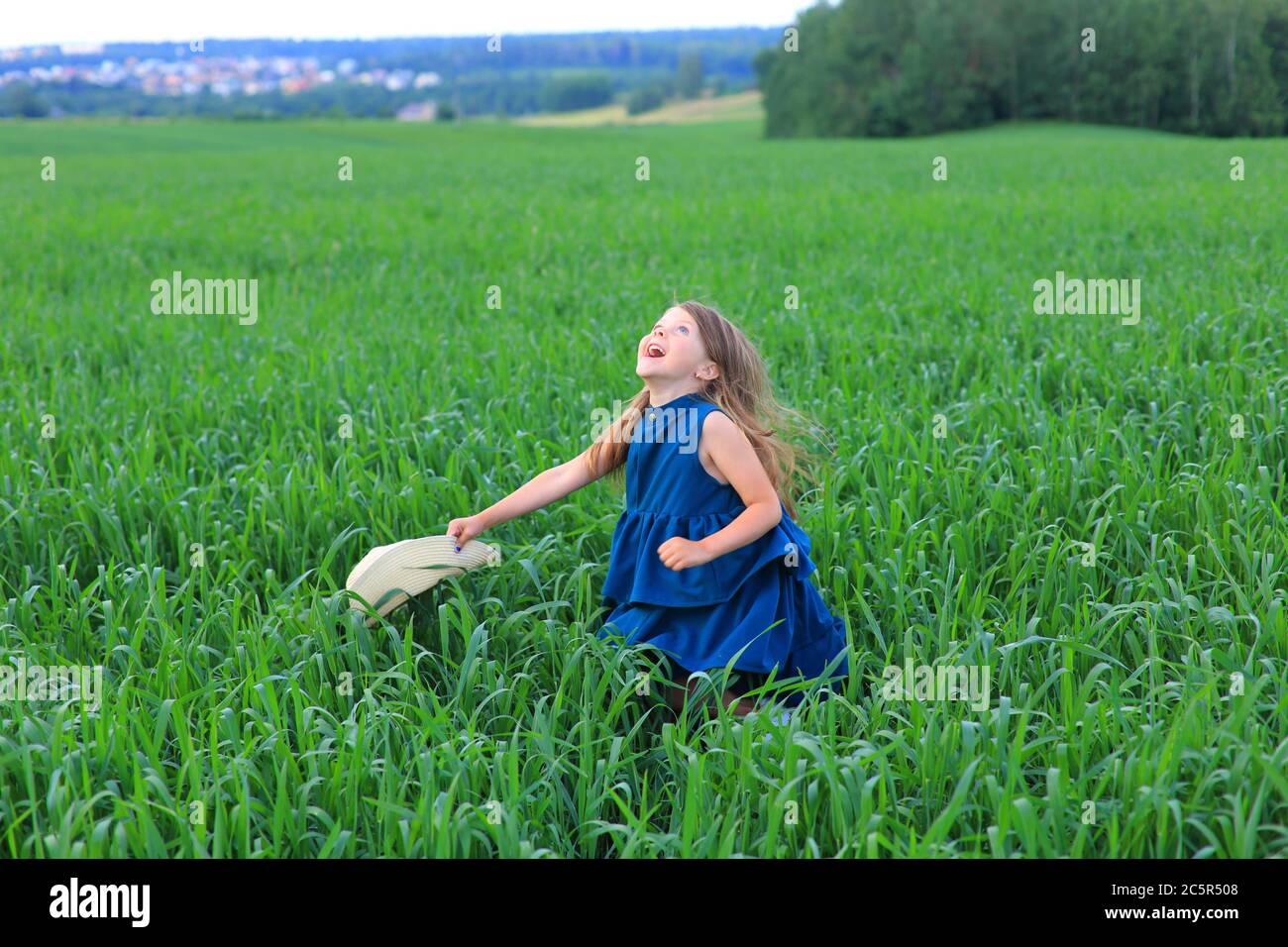 Beautiful little girl runs in the summer field Stock Photo