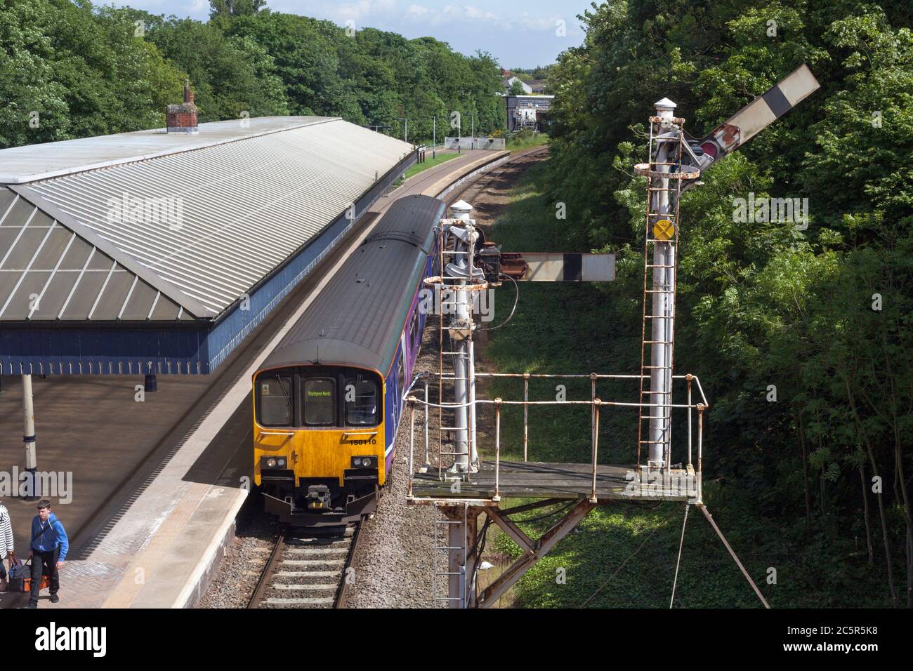 Northern Rail class 150 train passing the bracket semaphore signal at  Poulton-Le-Fylde railway station Stock Photo