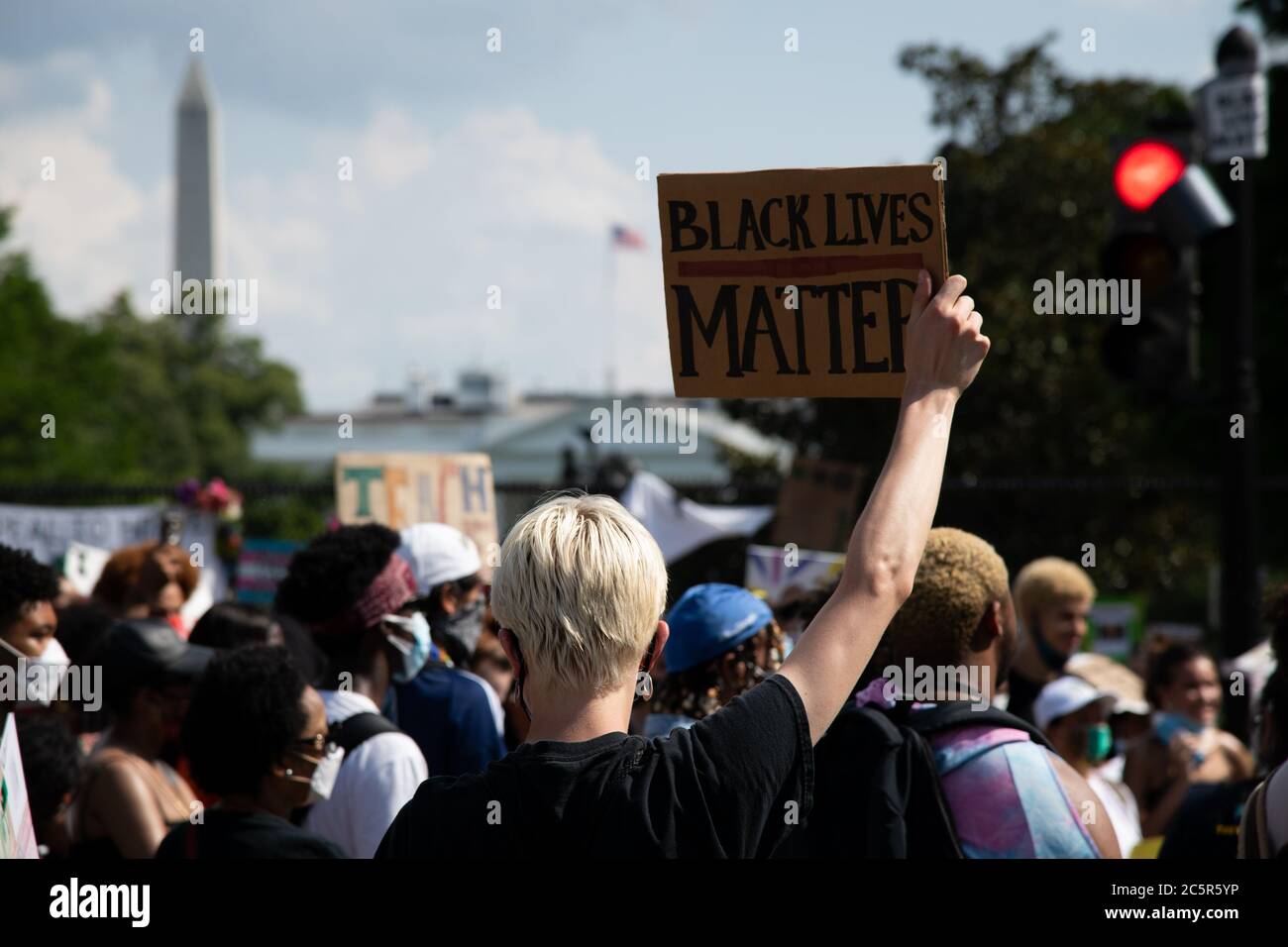 A racial justice protester holds a sign in Black Lives Matter Plaza near the White House in Washington, DC, on July 4, 2020, amid the coronavirus pandemic. Following a divisive speech by President Trump at Mt. Rushmore the night before, Fourth of July celebrations in Washington have proved controversial for the second year running C as racial justice protesters gathered for demonstrations across the city, the PresidentÕs Salute to America celebration is going ahead as planned despite CDC warnings about COVID-19 and numerous objections from local officials. (Graeme Sloan/Sipa USA) Stock Photo