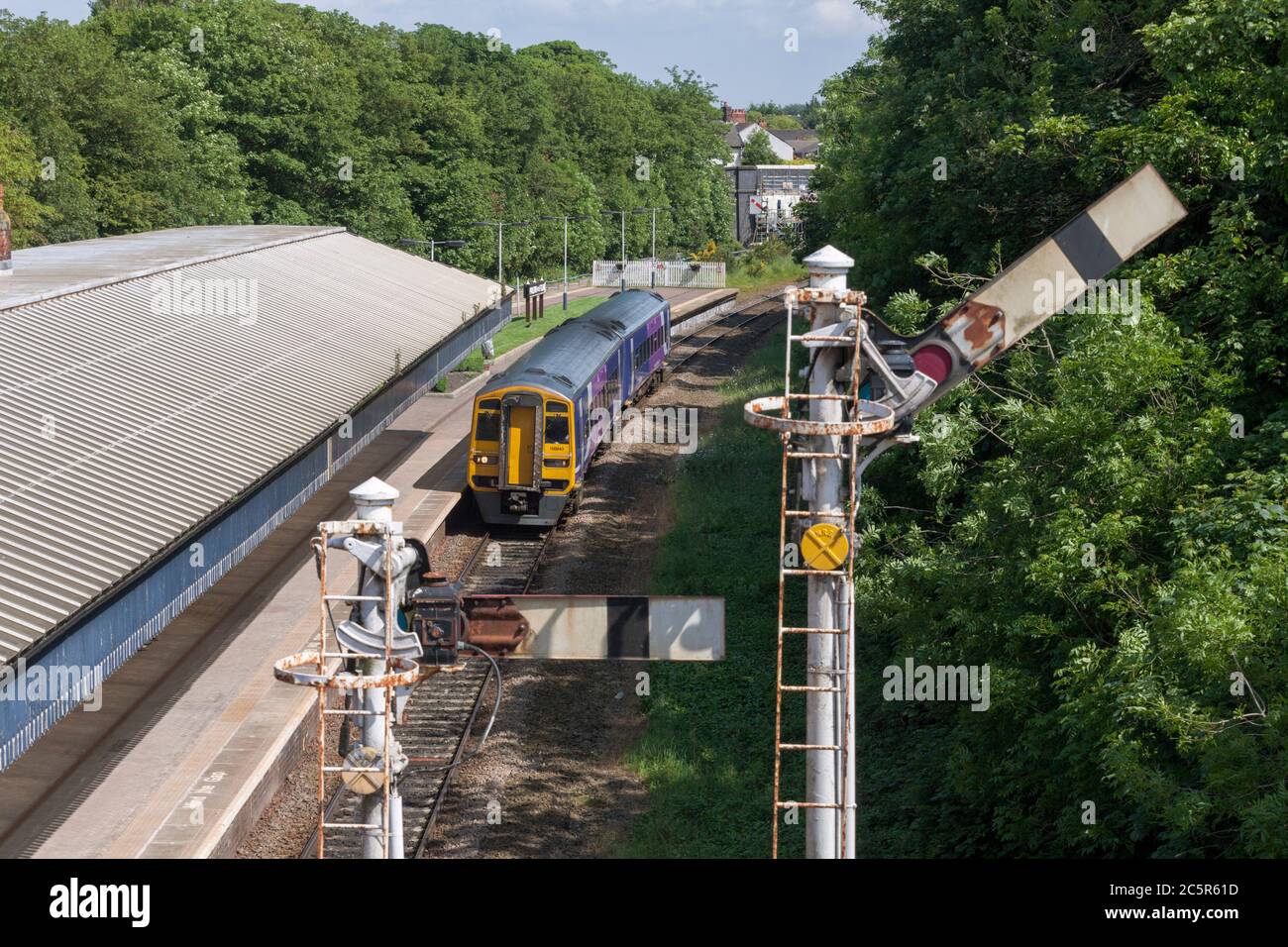 Northern Rail class 158 train passing the bracket semaphore signal at  Poulton-Le-Fylde railway station Stock Photo