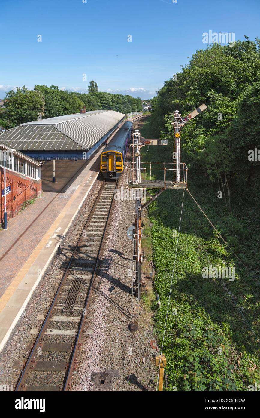 Northern Rail class 158 train passing the bracket semaphore signal at  Poulton-Le-Fylde railway station Stock Photo