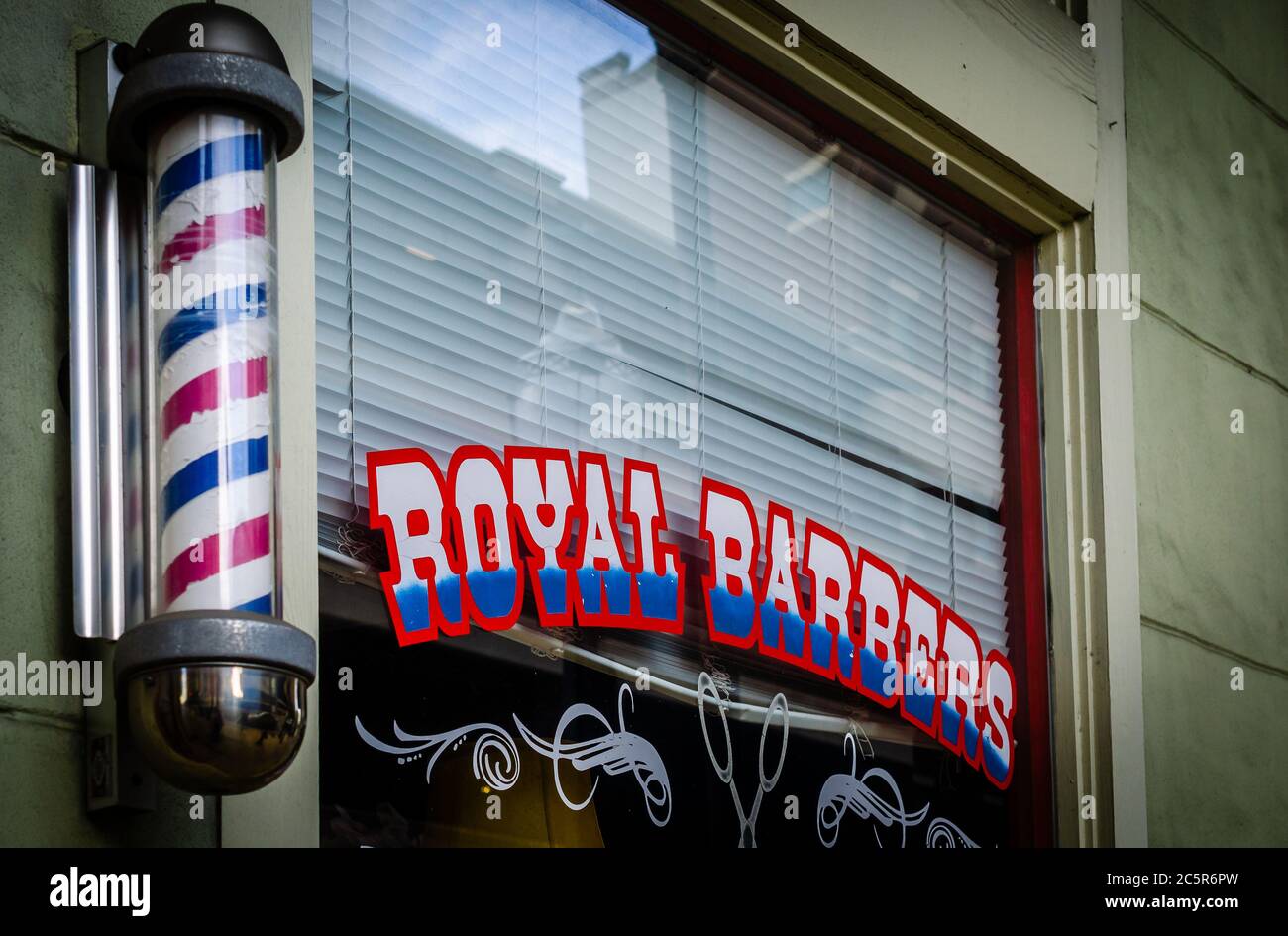 A vintage barber’s pole is displayed outside Royal Barbers, July 3, 2020, in Mobile, Alabama. Barber’s poles are a traditional trade sign. Stock Photo