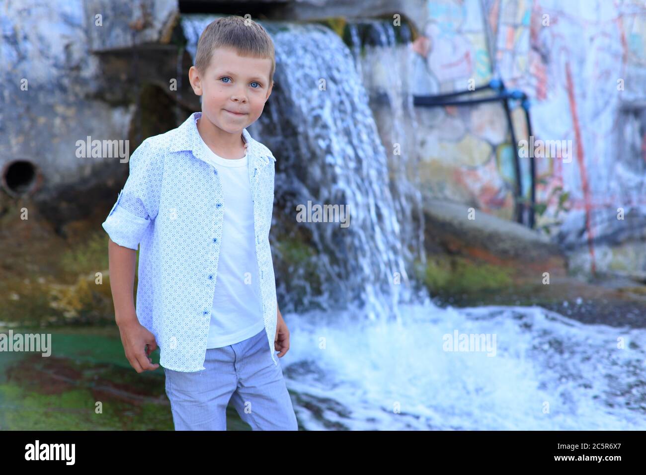 Portrait of a boy at the waterfall in summer Stock Photo