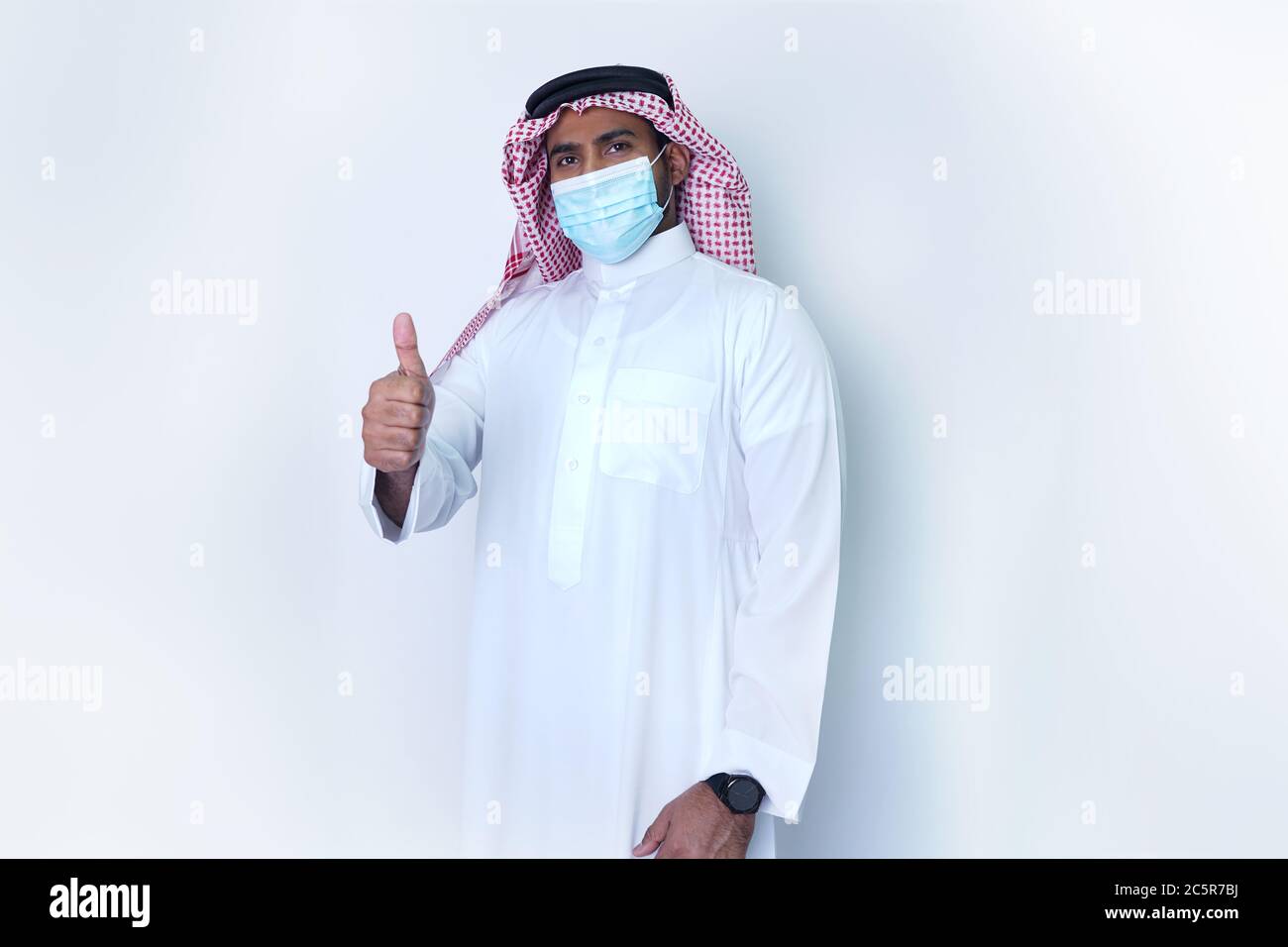 Saudi Arab Man standing in confidence showing thumps up after taking precautions due to Covid19 Stock Photo
