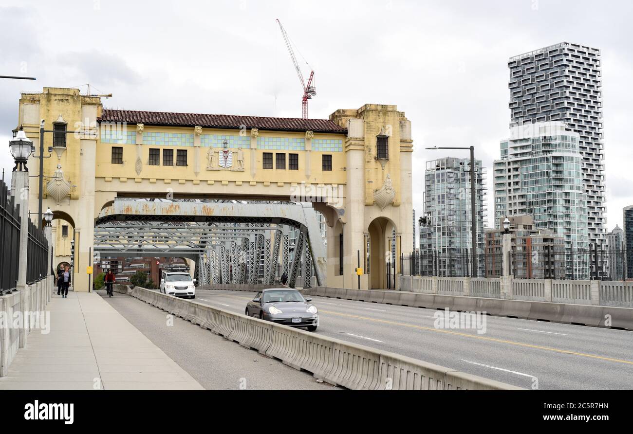 Traffic moves across the Burrard Street bridge next to a protected bike lane and a sidewalk in Vancouver, British Columbia, Canada. New residential to Stock Photo