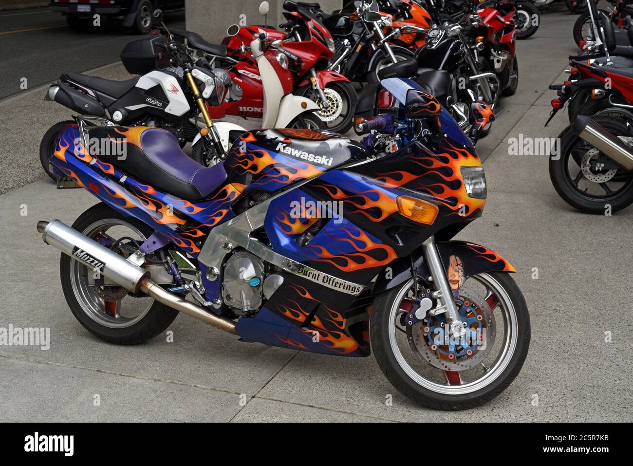 A Kawasaki motorcyle with a flame paint job sits with other bikes outside a  motorcycle dealership in Vancouver, British Columbia, Canada Stock Photo -  Alamy