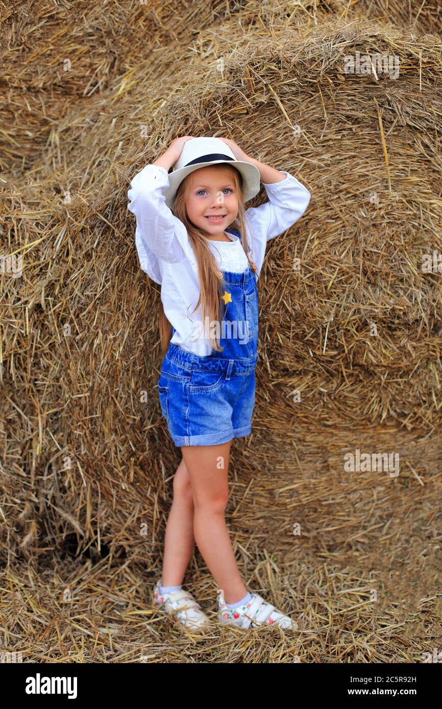 Portrait of a little girl on a haystack in summer Stock Photo - Alamy