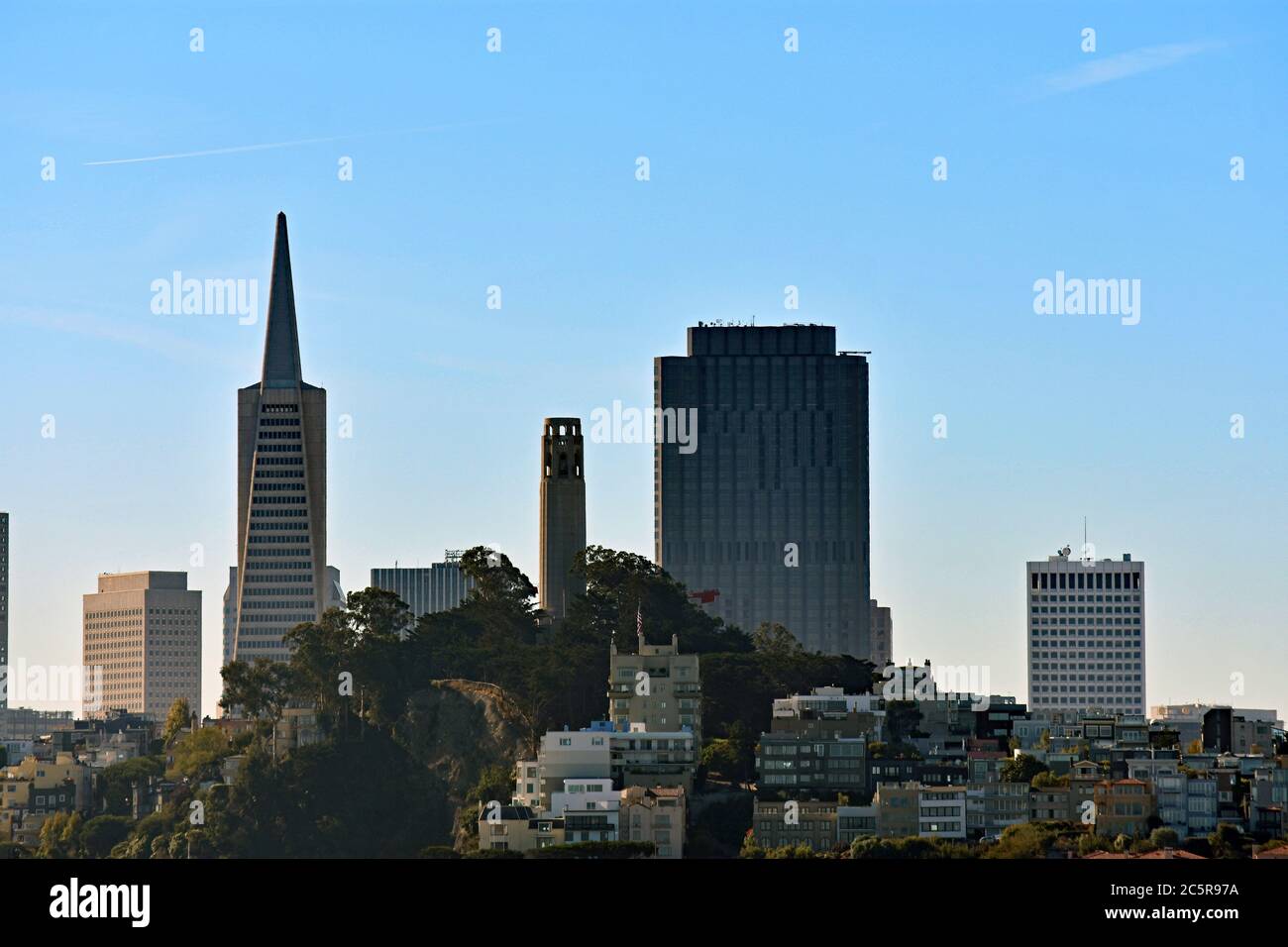 Coit Tower on Telegraph Hill, The Transamerica Pyramid and downtown city skyline seen from the San Francisco Bay at sunset.  San Francisco, California. Stock Photo