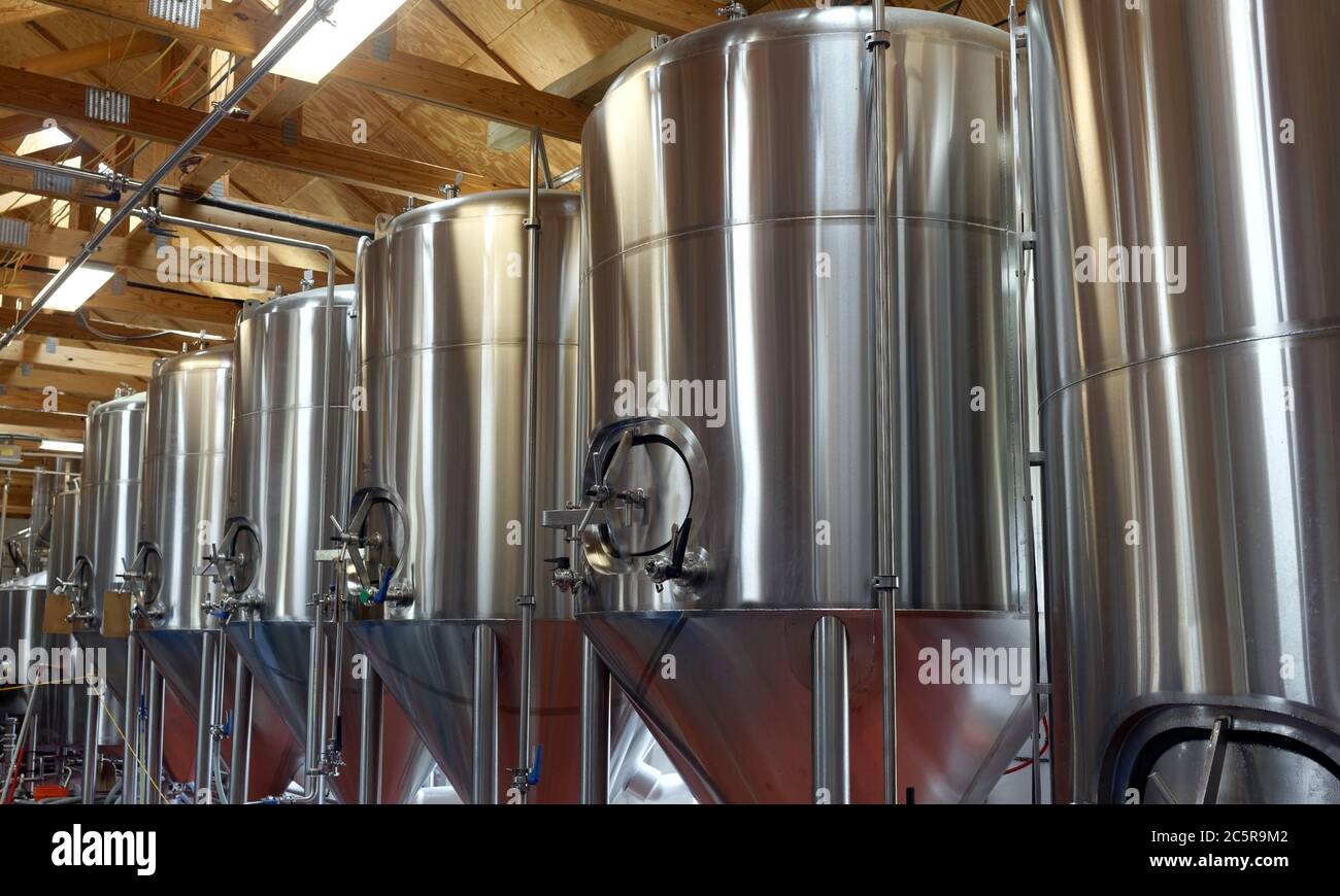 Row of shiny metal micro brewery tanks. Stock Photo