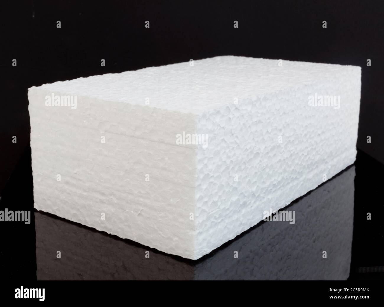 Single brick block of white styrofoam on black background. Horizontal. Stock Photo