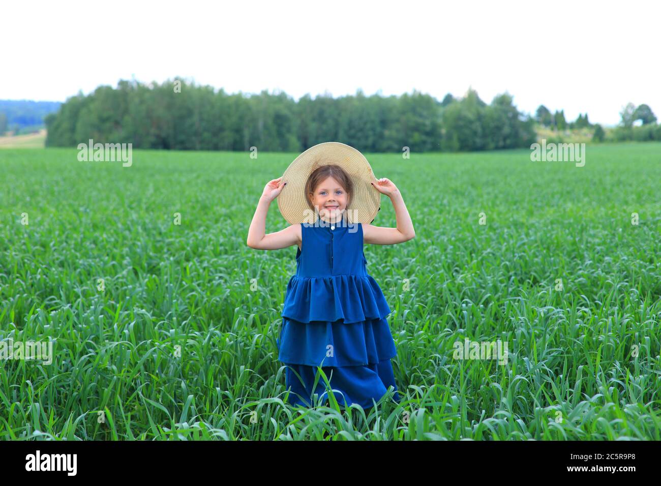 Beautiful little girl runs in the summer field Stock Photo