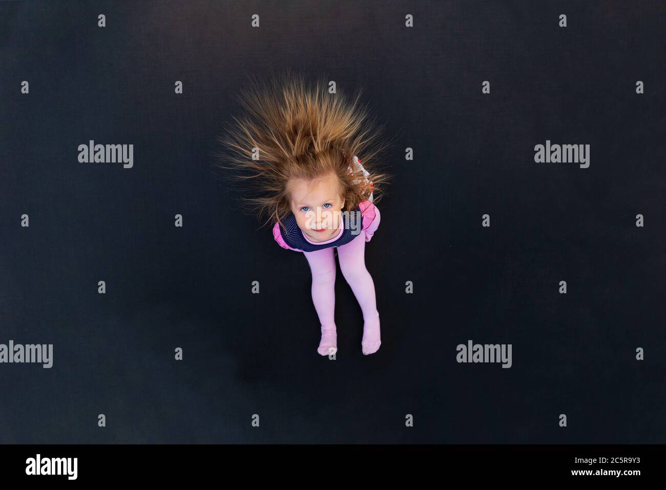 Portrait of a girl with electrified hair on a black background Stock Photo