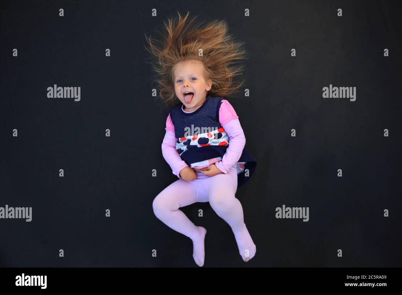 Portrait of a girl with electrified hair on a black background Stock Photo