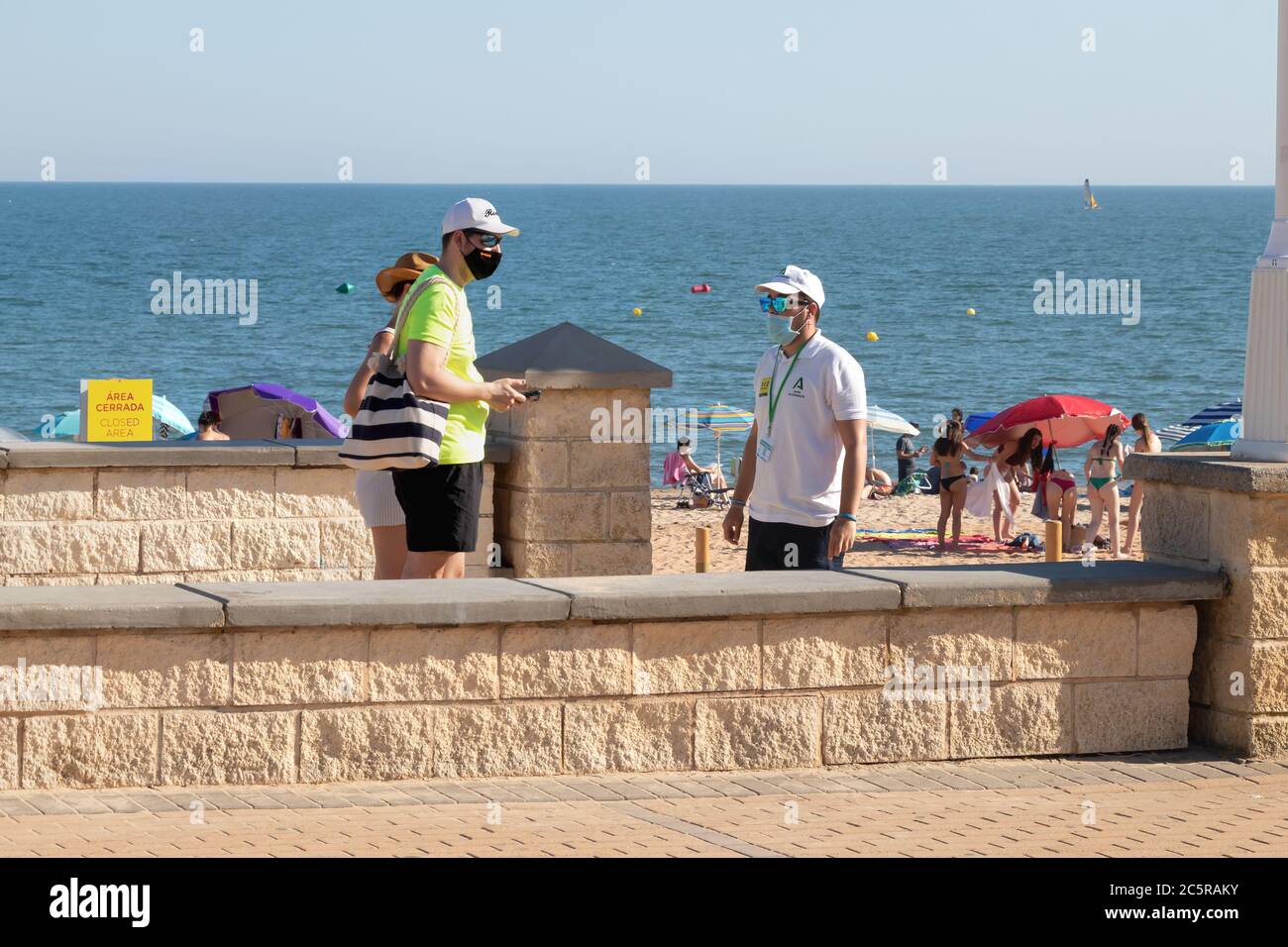 Huelva, Spain - July 4, 2020: Beach safety guard of Junta de Andalucia is controlling the access to Islantilla beach for coronavirus covid-19 preventi Stock Photo