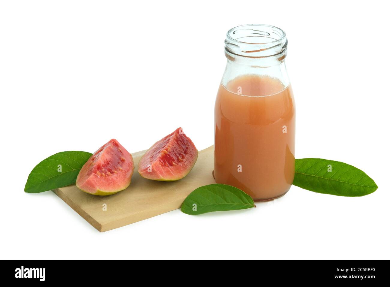 Fresh guava juice on a bottle glass above wood coaster with sliced