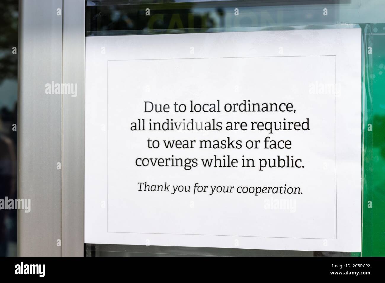 Store entrance exterior in Virginia with closeup of sign for all individuals customers required to wear face mask covering in public due to local ordi Stock Photo