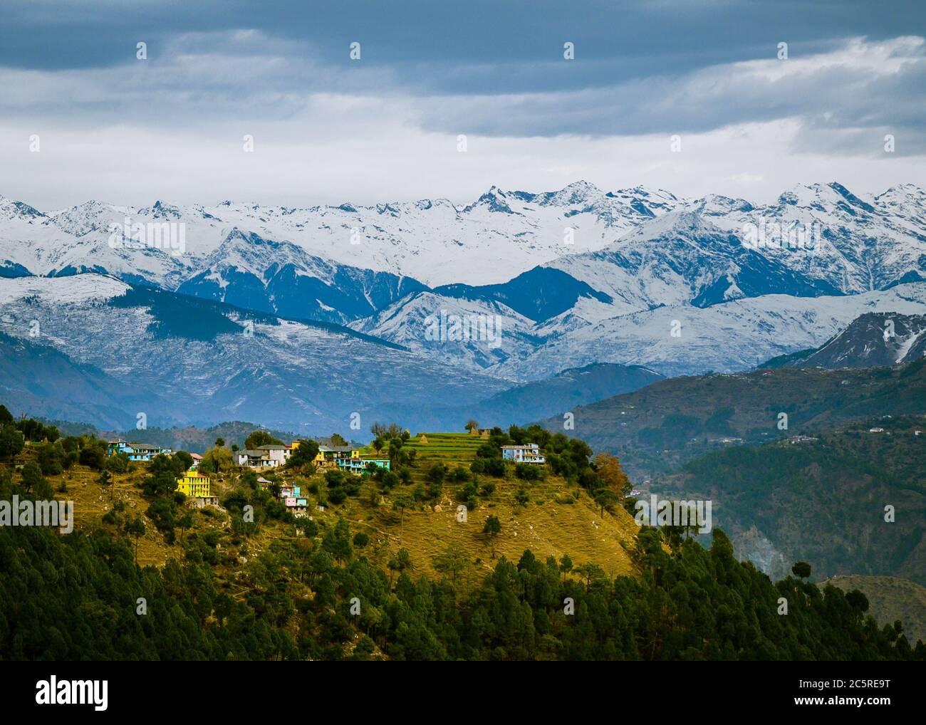 A scenic village in the backdrop of the snowcapped Himalayan mountains in winter. Himachal Pradesh, India. Stock Photo