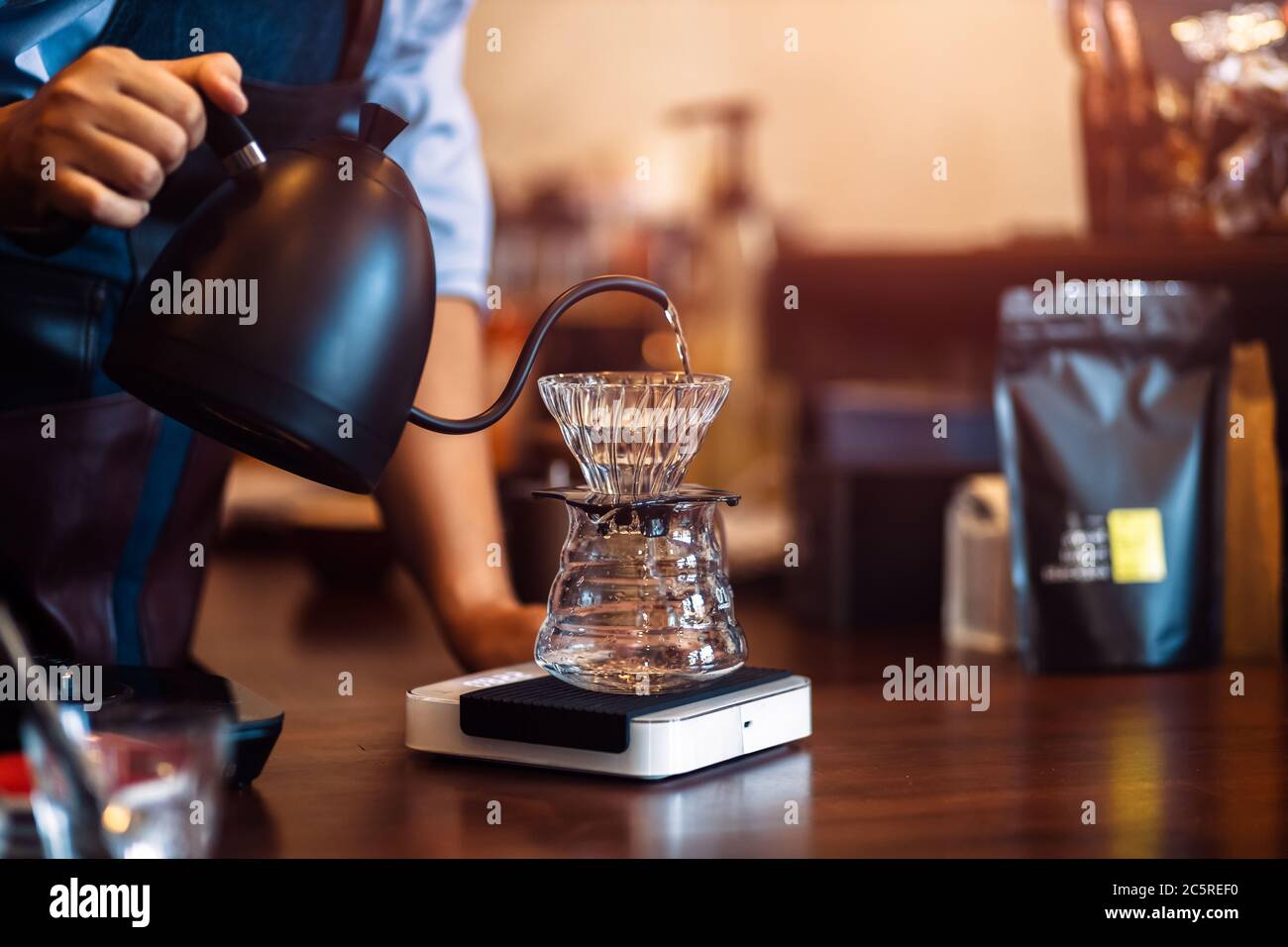 https://c8.alamy.com/comp/2C5REF0/barista-pouring-boiling-water-from-kettle-to-drip-coffee-maker-2C5REF0.jpg