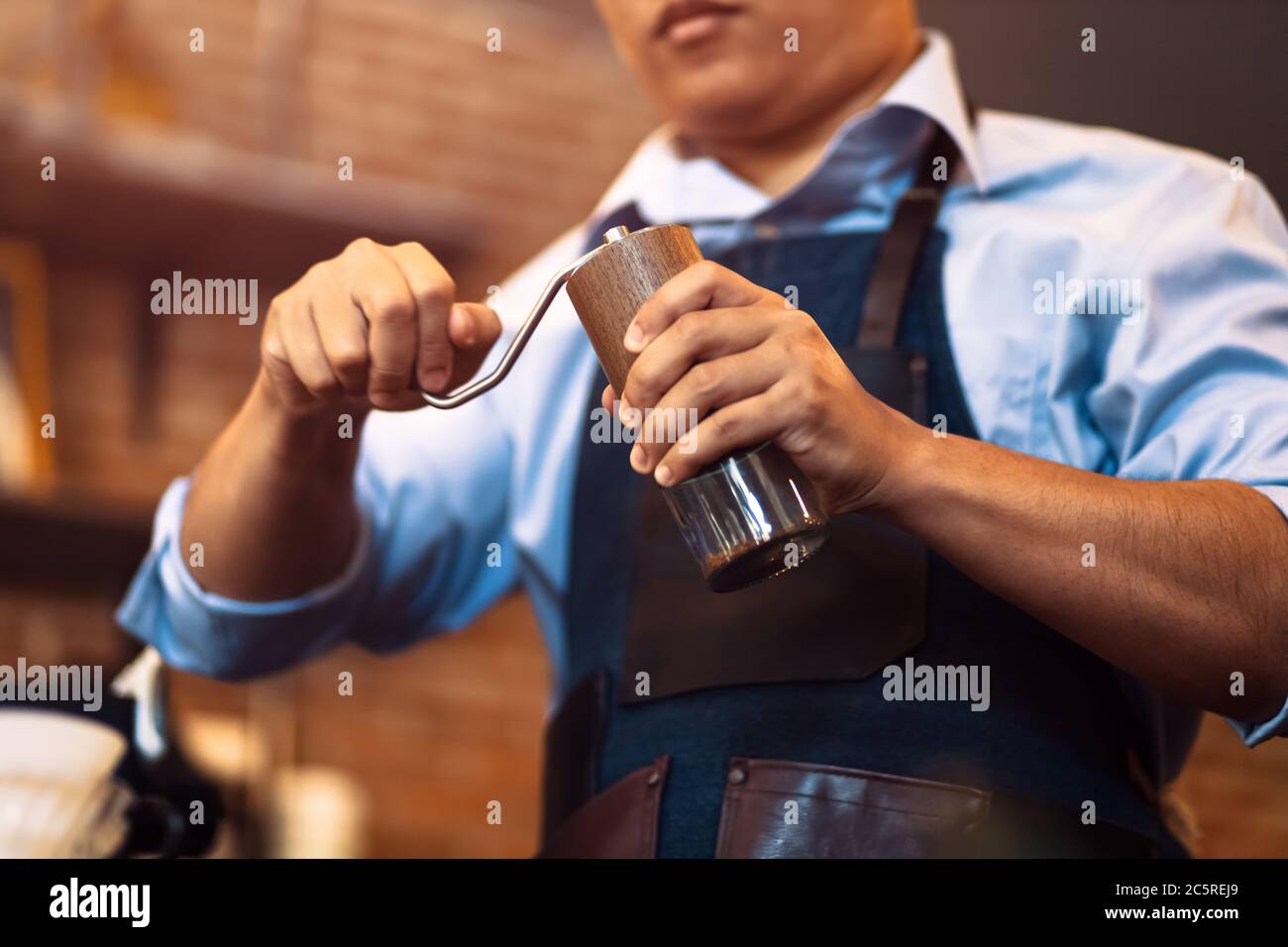 the barista hands on manual grinder coffee for grinding coffee beans at