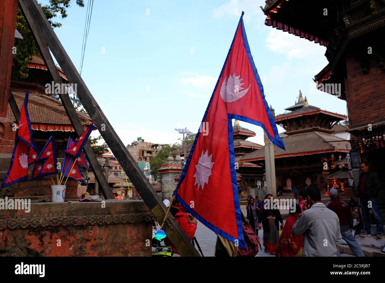 A big Nepali flag in Kathmandu Durbar Square along with smaller flags of Nepal Stock Photo