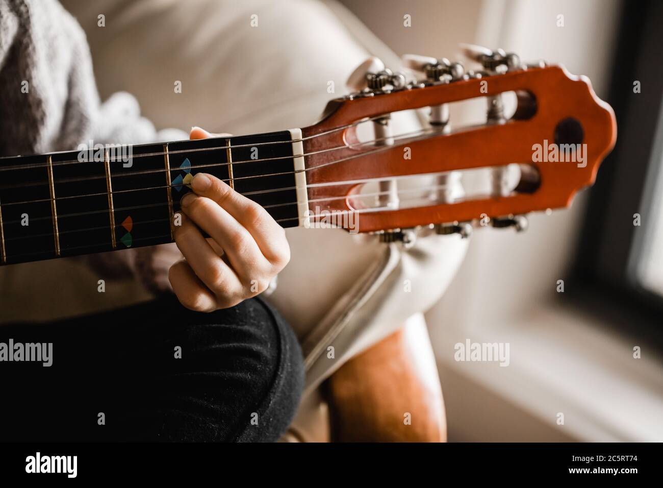 A young caucasion girl practicing playing her guitar Stock Photo - Alamy