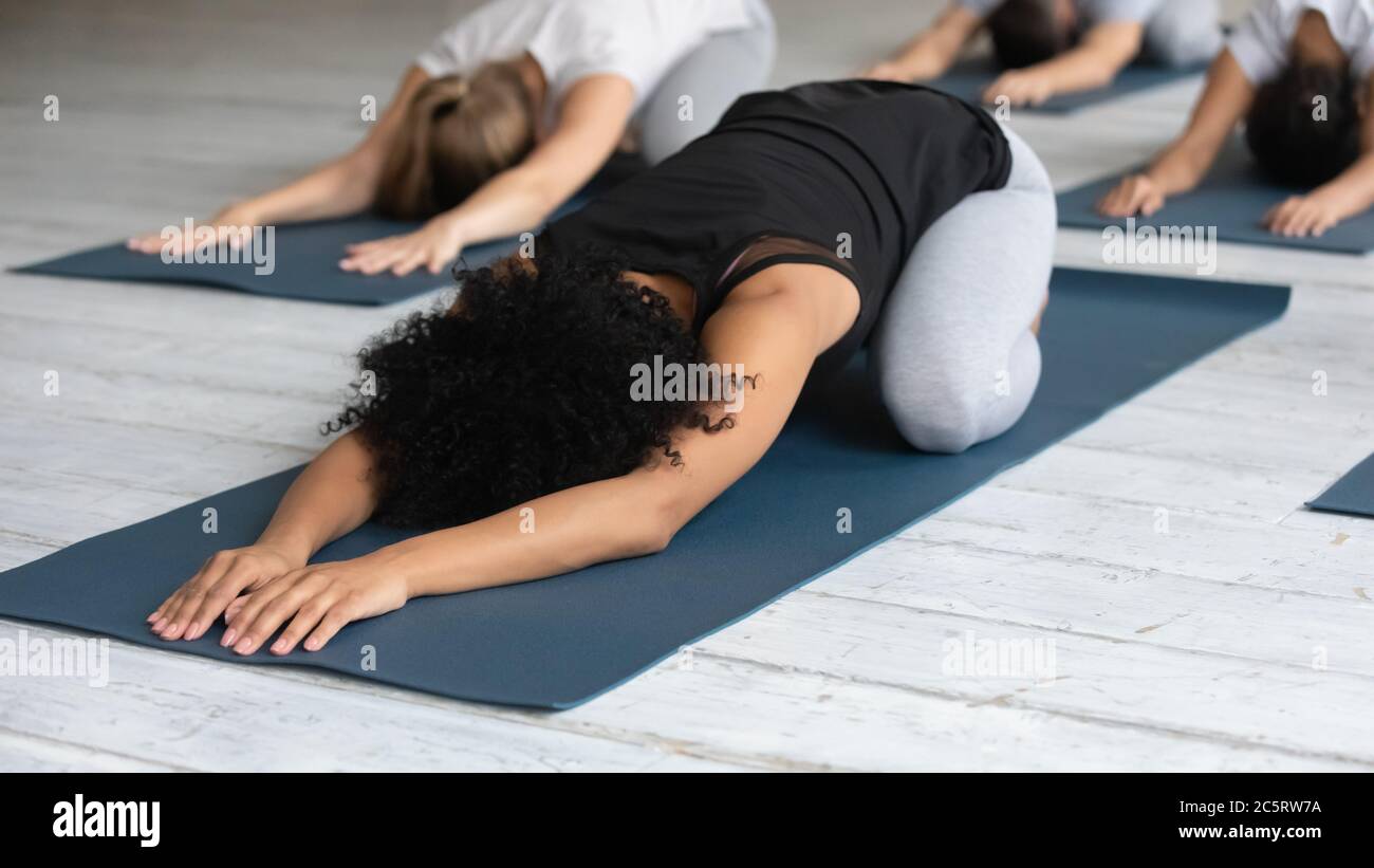 Young female african american instructor showing Child pose. Stock Photo